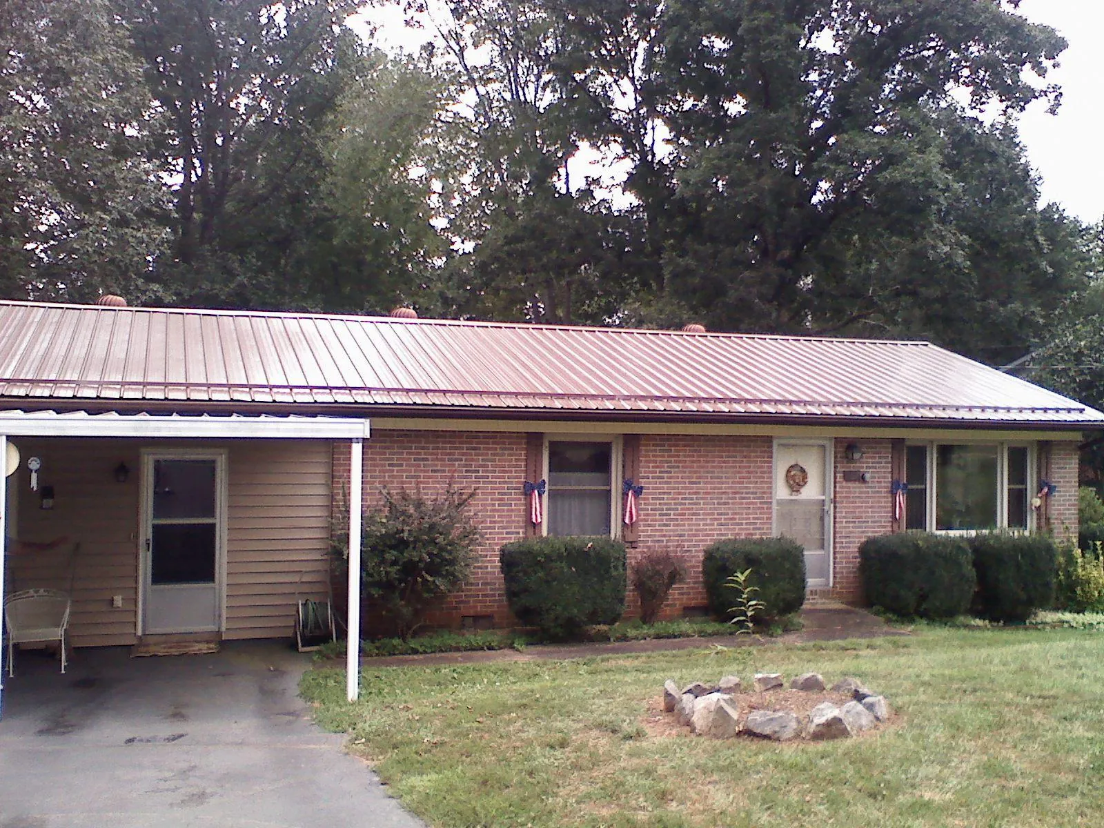 Bronze metal roof and carport on a brick ranch home — Roof Repair work by our crew in Reading