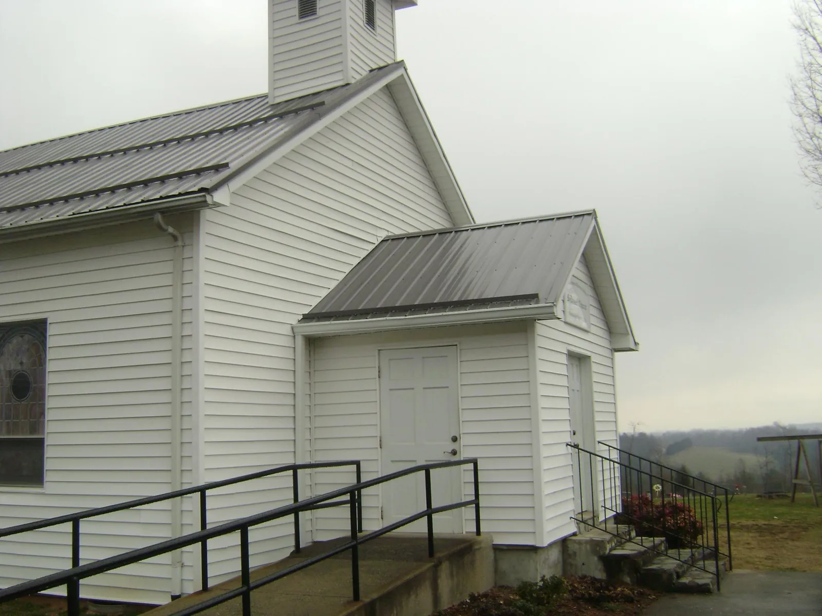 Gray metal roof on a white clapboard church with a steeple in Reading
